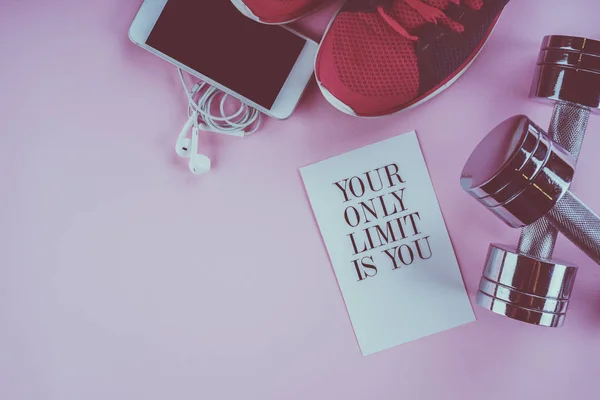 Baskets, téléphone et haltères sur fond rose — Photo