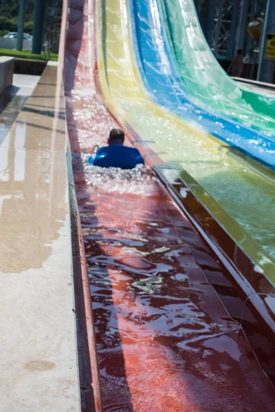 Der Junge fährt eine Rutsche im Wasserpark — Stockfoto