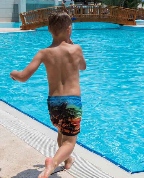 A boy is jumping into the pool — Stock Photo, Image