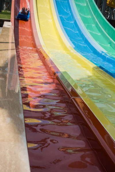 O menino monta um slide no parque aquático — Fotografia de Stock