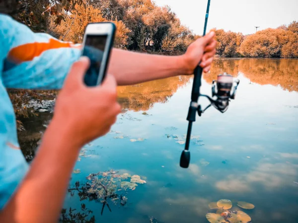 漁師は電話で夏に湖で釣りをしています — ストック写真