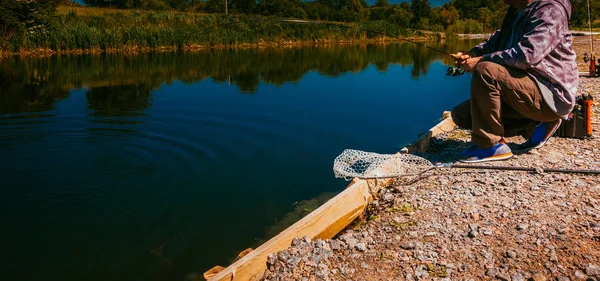 Pescador pegar truta arco-íris do lago — Fotografia de Stock