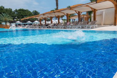 Çocuk havuza atlıyor.