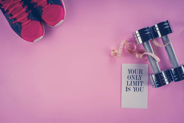 Sneakers, centimeter, dumbbells on a pink background — Stock Photo, Image