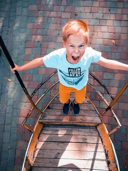 The boy is riding on a swing-boat — Stock Photo, Image