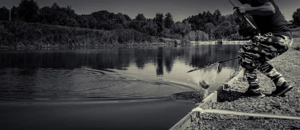 Pescador pegar truta arco-íris do lago — Fotografia de Stock