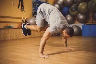 Genç adam bir spor salonunda trx devreye girer