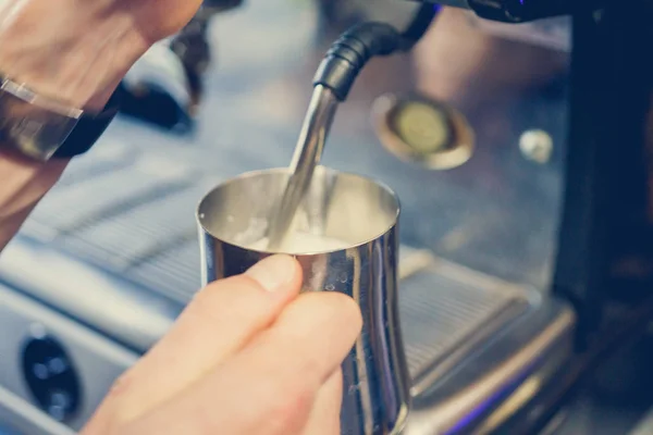 Eine Kaffeemaschine schenkt Milch ein — Stockfoto