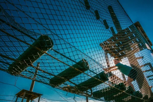 The boy climbs the rope park — Stock Photo, Image