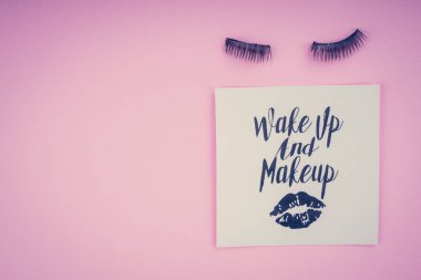 Pembe bir arka plan üzerinde çeşitli makyaj ürünleri