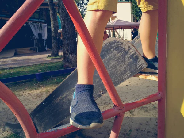 The child's legs climb on the swing — Stock Photo, Image