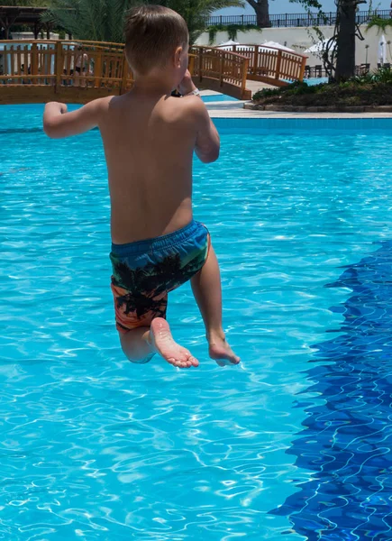 Chłopiec skacze do basenu — Zdjęcie stockowe