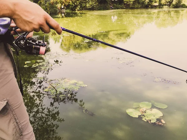 En fiskares hand med ett fiskespö — Stockfoto