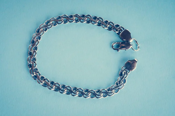 Bracciale in argento su sfondo blu — Foto Stock