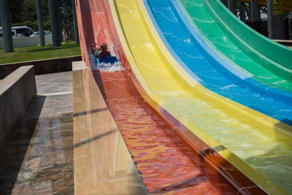 Le garçon monte un toboggan dans le parc aquatique — Photo