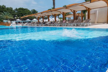 Çocuk havuza atlıyor.