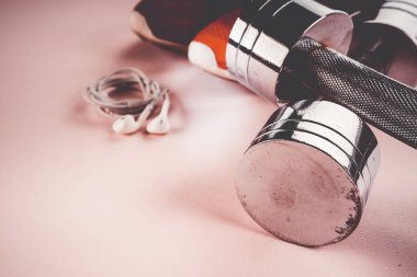 spor konsepti: spor ayakkabıları, halter, pembe backgr kulaklık