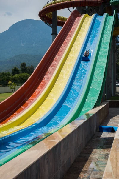 O menino monta um slide no parque aquático — Fotografia de Stock