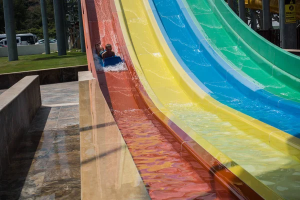 Il ragazzo cavalca uno scivolo nel parco acquatico — Foto Stock