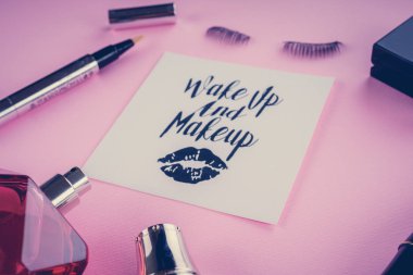 Pembe bir arka plan üzerinde çeşitli makyaj ürünleri