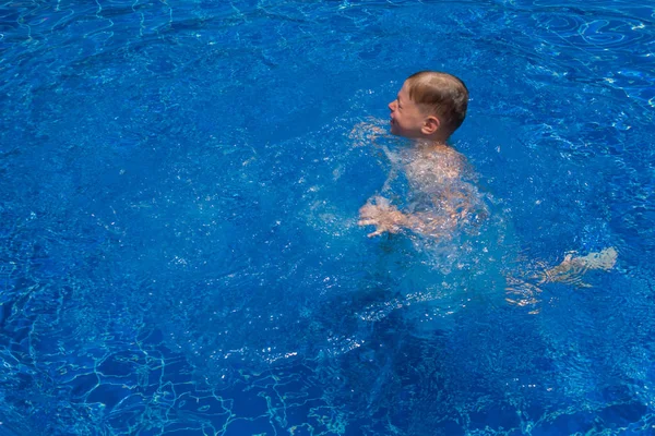 Pojken hoppar till poolen — Stockfoto