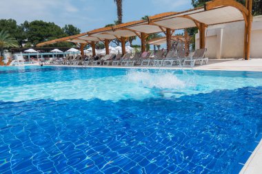 Çocuk havuza atlıyor.