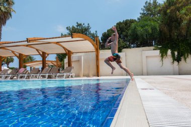 Çocuk havuza atlıyor.