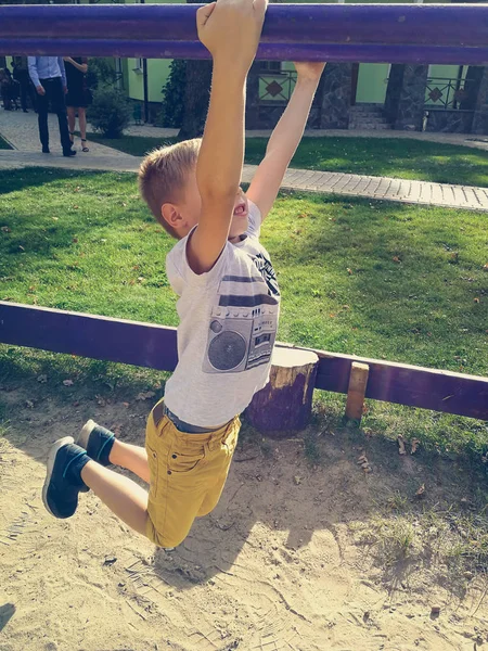 El chico está jugando en el patio de recreo — Foto de Stock