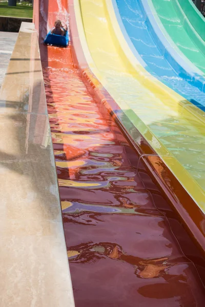 O menino monta um slide no parque aquático — Fotografia de Stock