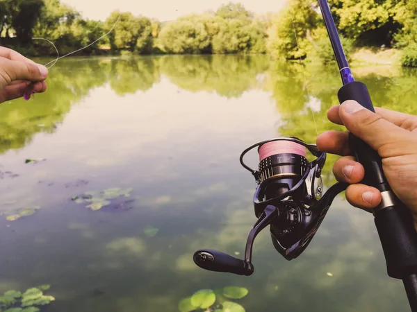 Mano di un pescatore con una canna da pesca — Foto Stock