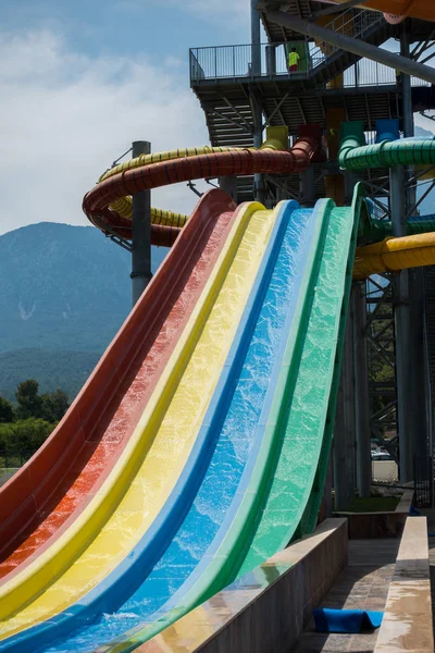 O menino monta um slide no parque aquático — Fotografia de Stock