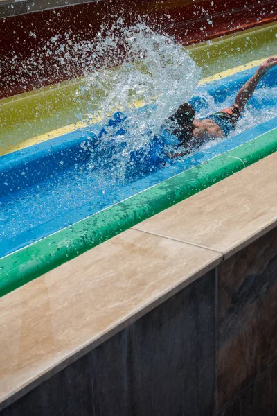 The boy rides a slide in the water park — Stock Photo, Image