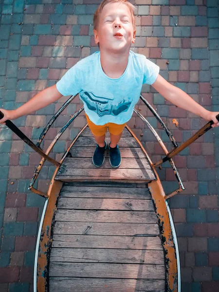 스윙 보트를 타고 있는 소년 — 스톡 사진