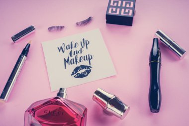 Pembe bir arka plan üzerinde çeşitli makyaj ürünleri