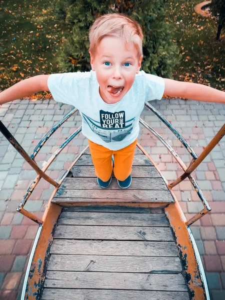 The boy is riding on a swing-boat — Stock Photo, Image