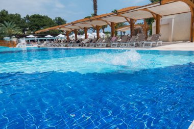 Çocuk havuza atlıyor.