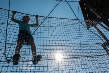 Çocuk ip parkında oynuyor.