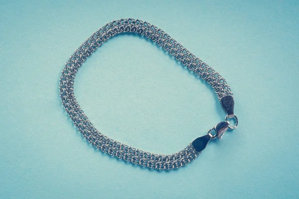 Bracciale in argento su sfondo blu — Foto Stock