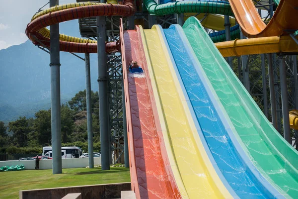 O menino monta um slide no parque aquático — Fotografia de Stock