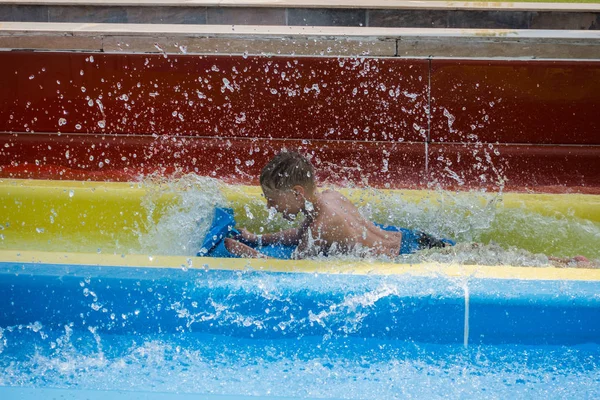 El chico monta un tobogán en el parque acuático — Foto de Stock