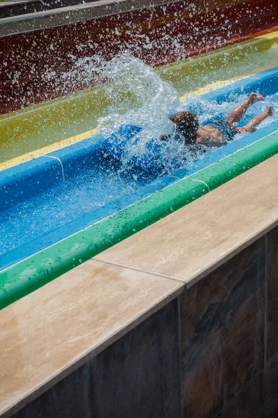 De jongen rijdt een dia in het waterpark — Stockfoto