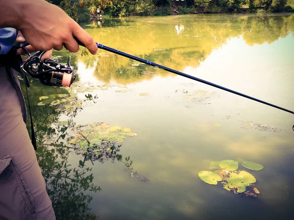 Mano di un pescatore con una canna da pesca — Foto Stock