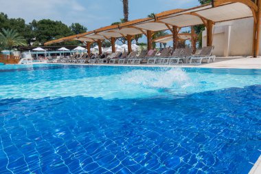 Çocuk havuza atlıyor.