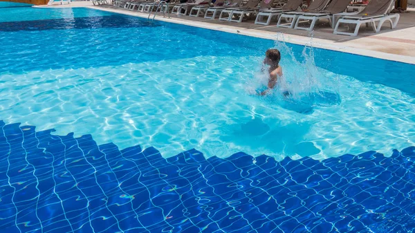 A fiú a medencébe ugrik. — Stock Fotó