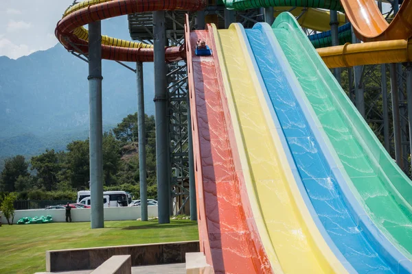 El chico monta un tobogán en el parque acuático —  Fotos de Stock