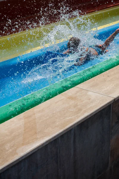 Le garçon monte un toboggan dans le parc aquatique — Photo