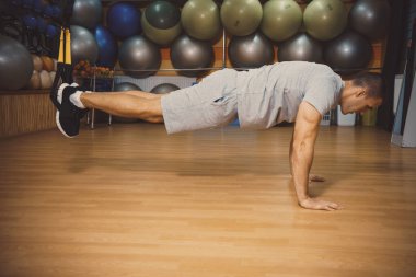 Genç adam bir spor salonunda trx devreye girer