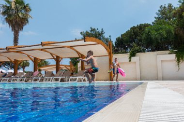 Çocuk havuza atlıyor.