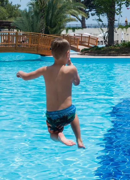 A boy is jumping into the pool — Stock Photo, Image