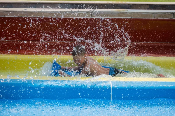 水公園のスライドに乗る少年 — ストック写真